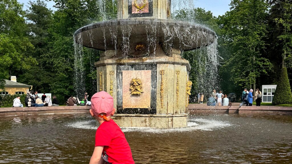 Фонтаны Петергофа — ребёнок играет у фонтана в Нижнем парке