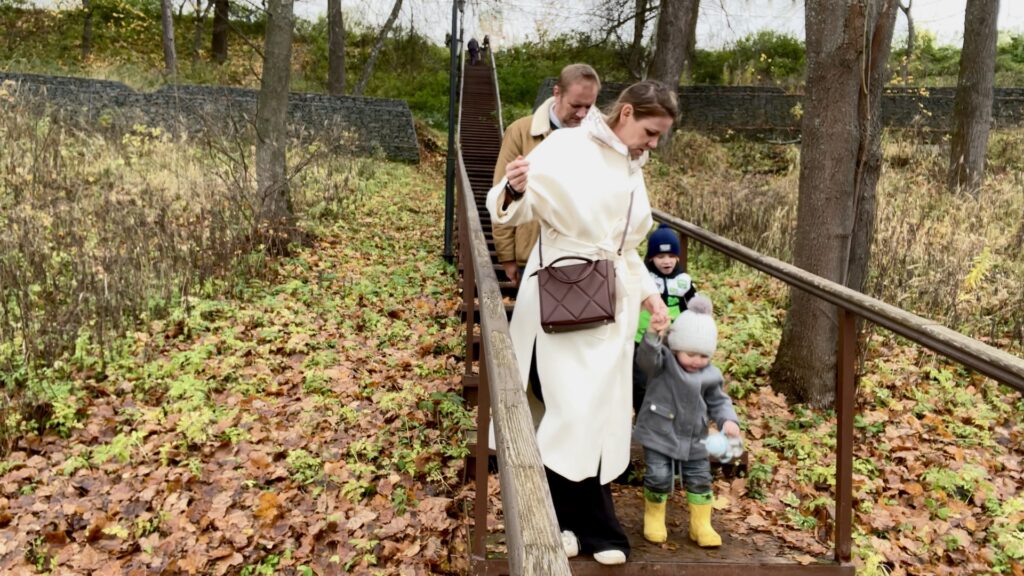 Семья спускается по лестнице в осеннем овраге Звенигорода