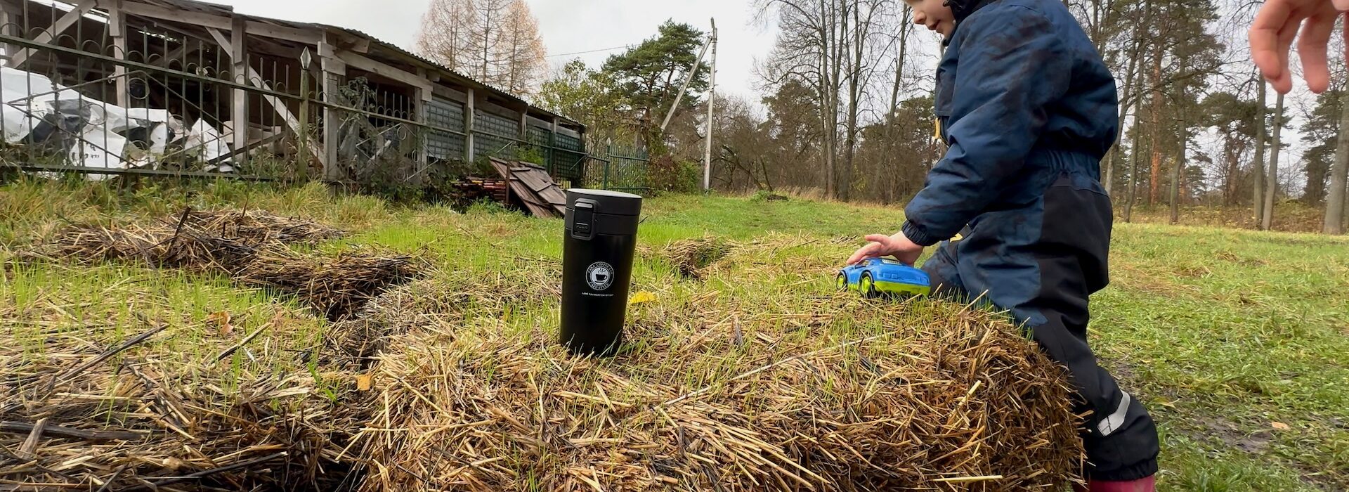Ребёнок играет на стоге сена, чашка кофе на фоне осеннего утра в Звенигороде